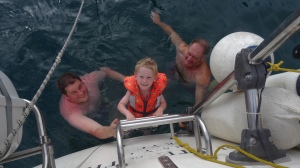 Tommy swimming on the back of the boat with Grandad and Daddy