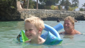 Tommy taking to the water with his waterwings and blue 'noodle' float.